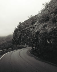 Road amidst trees against clear sky