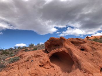 Rock formations in desert against cloudy sky