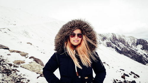 Portrait of young woman standing in snow