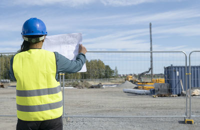 Woman holding blueprint at construction site