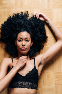 Portrait of woman with arms raised on floor