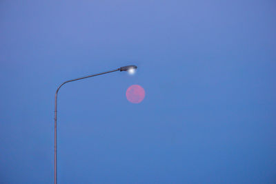 Low angle view of street light against blue sky