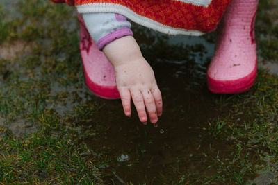 Low section of girl playing in puddle