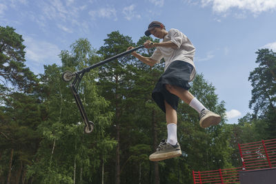 The boy performs extreme stunts jumping with a scooter, extreme sports, jumping in the air