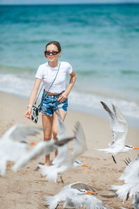 Full length of young woman standing at beach