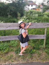 Portrait of smiling young woman standing against trees