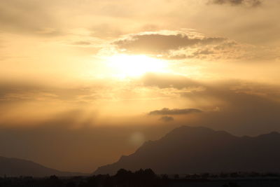 Scenic view of silhouette mountains against sky during sunset