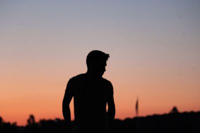 Silhouette man standing against sky during sunset