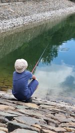 Rear view of a man overlooking calm lake