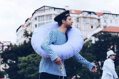 Man in sailor costume looking away while standing at carnival