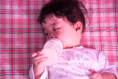 Close-up of baby girl with milk bottle