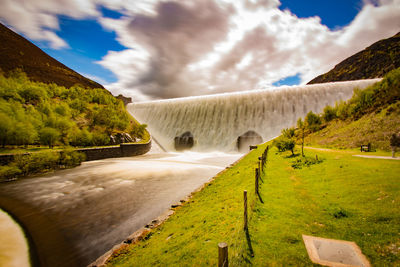 Scenic view of waterfall against sky