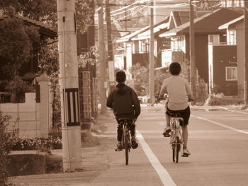 Rear view of man riding bicycle on street