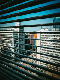 Modern buildings against sky seen through glass window