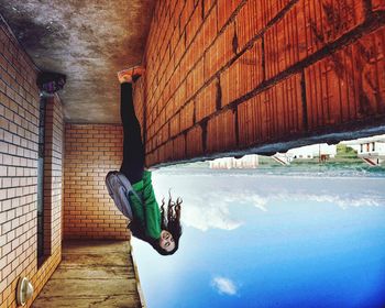 Low angle view of person against wall in building