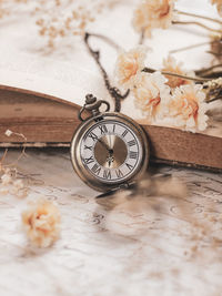Pocket watch with vintage book and flowers. stillife concept