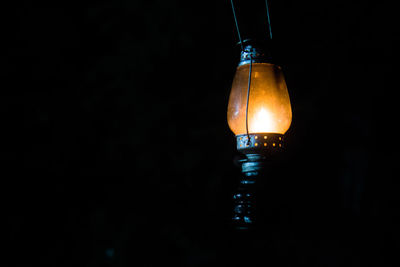 Close-up of lit lantern over black background