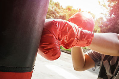 Close-up of man punching bag outdoors