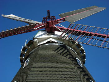 Low angle view of traditional windmill against clear blue sky