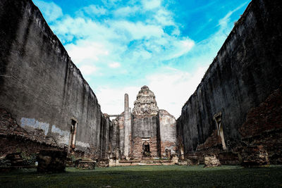 Low angle view of old building against cloudy sky