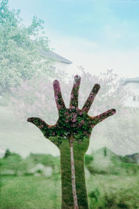 Digital composite image of tree on field against sky