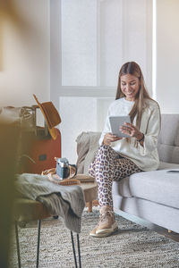 Young woman using laptop while sitting on chair at home