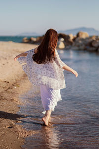 Rear view of woman walking on beach