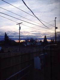 Electricity pylon against cloudy sky