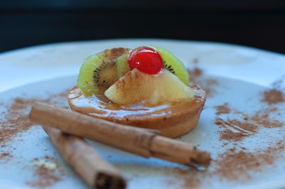 Close-up of dessert with fruits and cinnamons in plate