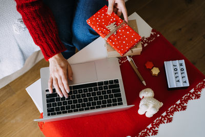 Midsection of woman using laptop on table