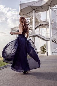 Woman holding umbrella while standing outdoors