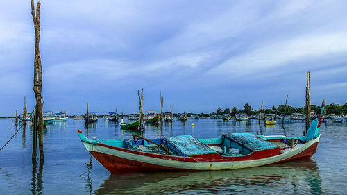 Boats moored in sea against sky