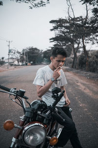 Side view of man riding motorcycle on road