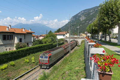 Train on railroad tracks in city against sky