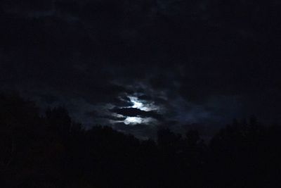 Low angle view of silhouette man against moon in sky