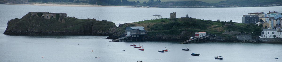 Panoramic view of people on pier over sea