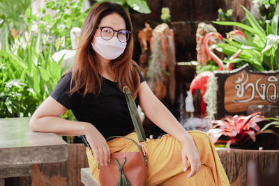 Portrait of woman wearing mask while sitting at cafe