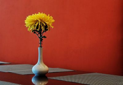 Close-up of yellow flower vase on table