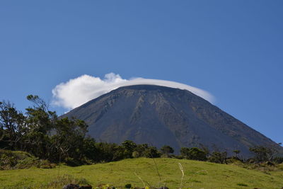 Scenic view of mountains against blue sky