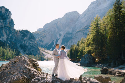 Woman with umbrella on mountain against mountains