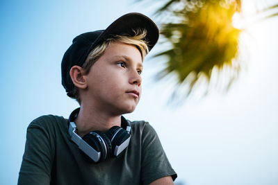 Portrait of young man looking away against sky