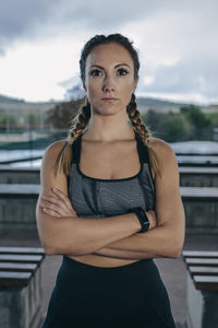 Portrait of beautiful young woman standing against blurred background