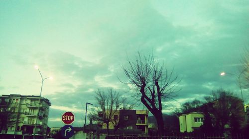 Low angle view of bare tree against cloudy sky