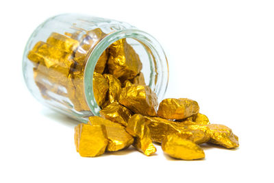 Close-up of yellow glass jar on white background