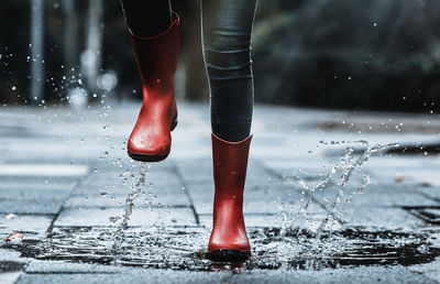 Low section of man standing on wet floor during rainy season