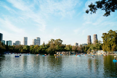 Scenic view of river by buildings against sky