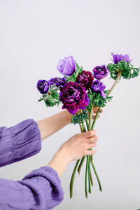 Low section of woman holding flowers