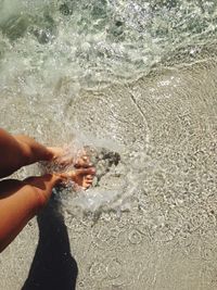 Low section of person on sand at beach