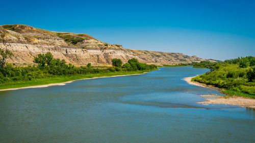 Scenic view of beach against clear blue sky
