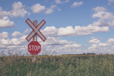 Information sign on field against sky